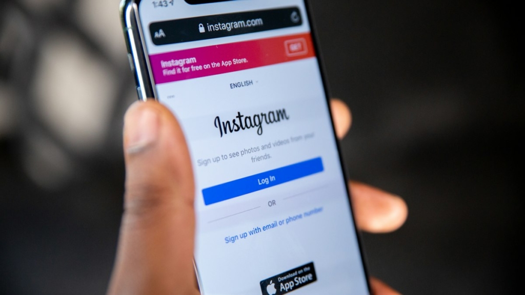 Ekranında Instagram logosu görünen akıllı telefonu tutan el