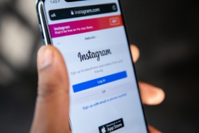Ekranında Instagram logosu görünen akıllı telefonu tutan el