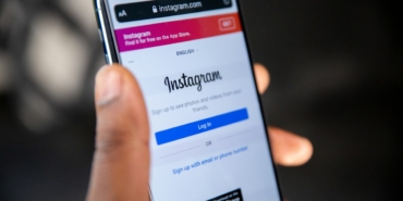 Ekranında Instagram logosu görünen akıllı telefonu tutan el