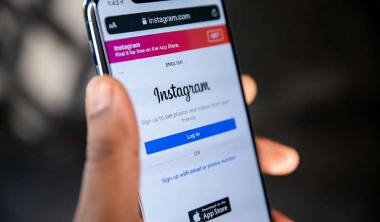 Ekranında Instagram logosu görünen akıllı telefonu tutan el