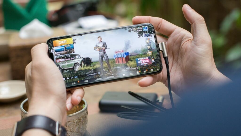 Yatay tutulan telefonda mobil oyun oynayan kişi (temsili görsel)