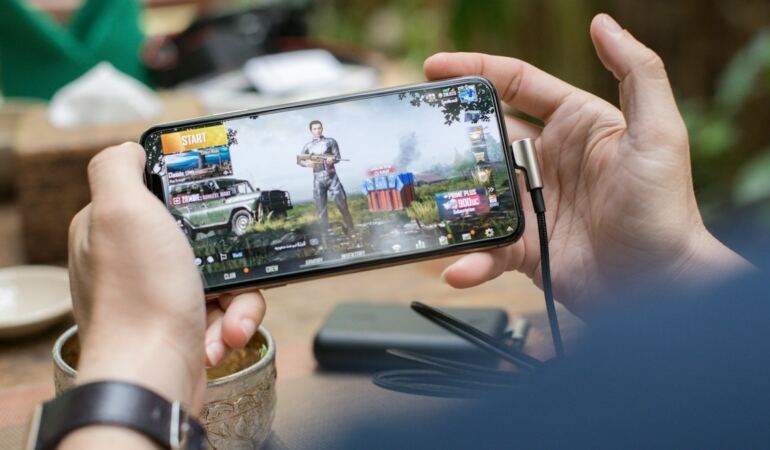 Yatay tutulan telefonda mobil oyun oynayan kişi (temsili görsel)